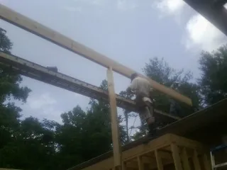 Carpenter setting a ridge beam over a new addition frame — Ice Dam Removal by Roofing Brothers in Palm Beach